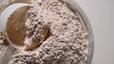 Bir kasede protein tozu ve kepçe. Besin takviyesi spor gıdası. Yüksek kaliteli FullHD görüntüler