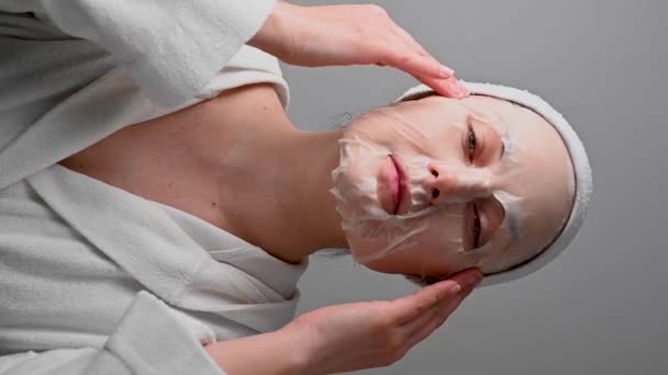 Woman Applying Textile Face Mask Skin Care Moisturising Cosmetic Procedure — Vídeo de stock