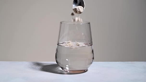 水のガラスにコラーゲンまたはタンパク質粉末を追加します 健康管理の概念だ 高品質のフルHd映像 — ストック動画