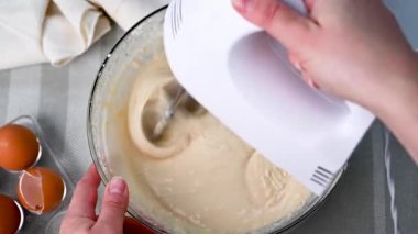Mixing dough with hand mixer, cooking a cake, top view. Home baking.