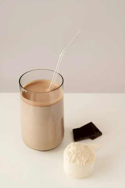 Protein shake, drink with protein rice powder with glass straw. Vertical photo