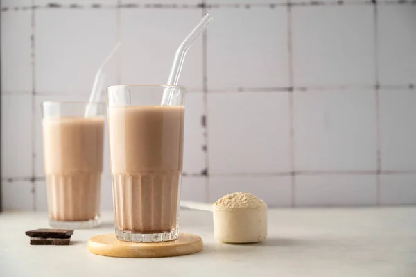 Chocolate protein shake drink glasses with protein powder, copy space for text