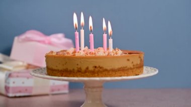 Doğum günü pastası. Yakıcı mumlar üfleme, hediye kutuları, renkli mavi arka plan. Yüksek kalite 4k görüntü