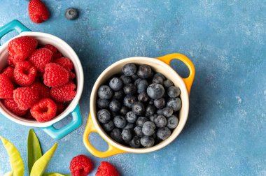Fresh berries. Blueberry and raspberry in ceramic bowls. Colourful fruit, food background, top view