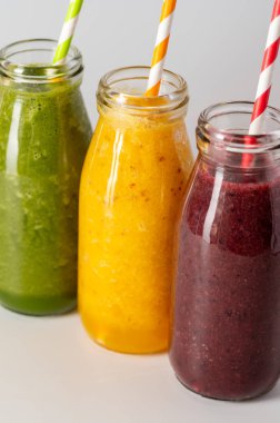 Fresh fruit smoothies bottles with straws. Healthy detox drinks.