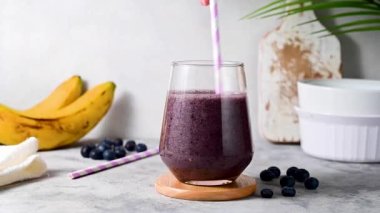 Mixing berry smoothie. Pouring banana, raspberry, blueberry smoothie in glass