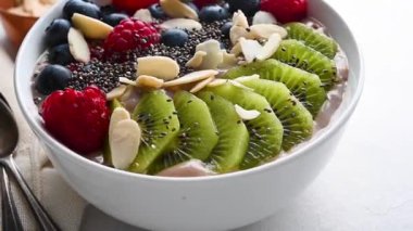 Delicious smoothie bowl with berries, kiwi, raspberries and chia seeds. High quality FullHD footage