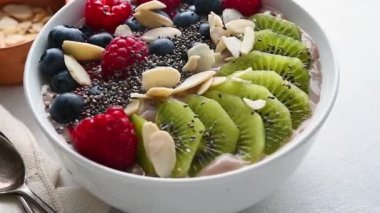 Delicious smoothie bowl with berries, kiwi, raspberries and chia seeds. High quality FullHD footage
