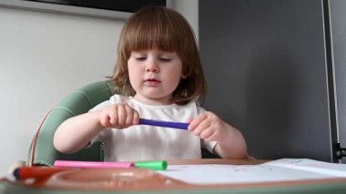 Cute toddler with crayons, colourful pencils