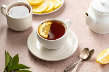 Drinking tea, white ceramic cup of black tea and lemon slice. Slow living concept