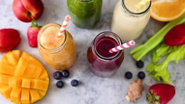 Fresh fruit smoothies bottles with straws. Healthy detox drinks.