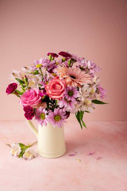 Beautiful fresh spring flowers. Pink bouquet of flowers in vase, on pink background
