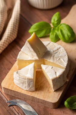 Brie, soft cheese slices on cutting board. Close up.