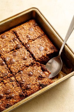 Close up brownies with chocolate chips and rolled oats served with cup of tea