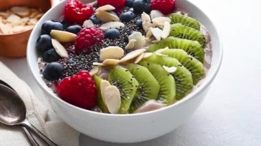 Delicious smoothie bowl with berries, kiwi, raspberries and chia seeds. High quality FullHD footage