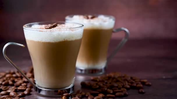 Zwei Tassen Kaffee Heißgetränke Mit Milchschaum Glasbechern Über Holzhintergrund — Stockvideo