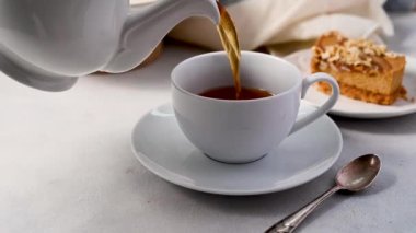 Beyaz çay, seramik bardak, karamel peynirli kek. Yüksek kalite 4k görüntü