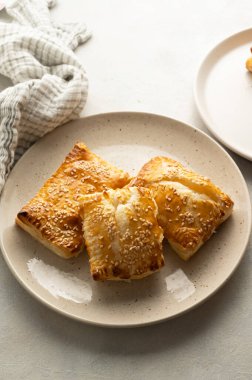 Puff pastry dough. Folded baked puff pastry pies in a plate