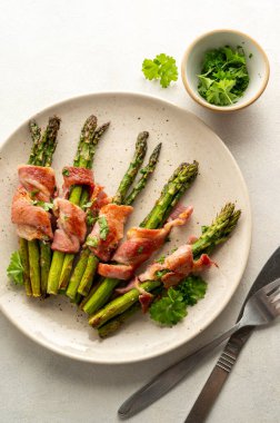 Wrapped asparagus with bacon in a plate. Top view.
