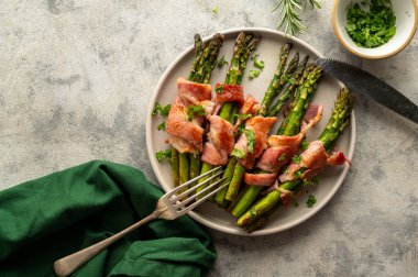 Wrapped asparagus with bacon in a plate. Top view.