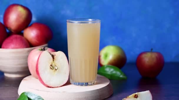 苹果果汁杯 有新鲜的红苹果 色彩斑斓的蓝色背景 — 图库视频影像