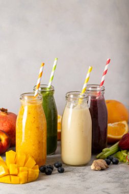 Meyve suyu ve renkli pipetli şişeler. Sağlıklı detoks içecekleri.