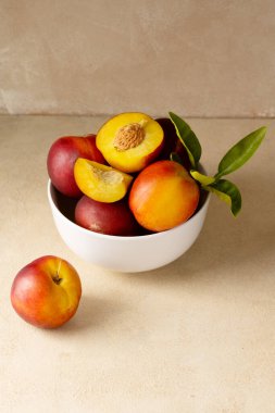 Nectarine peaches fruits in a bowl. Neutral background