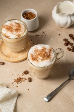 Two glass cups with coffee drink, latte with milk foam