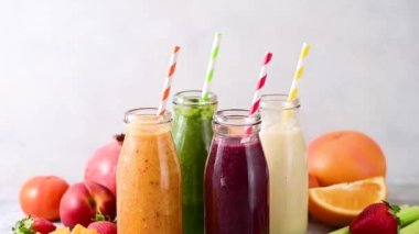 Fresh fruit colourful smoothies bottles with straws. Healthy detox drinks.