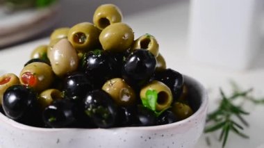Bir kasede siyah ve yeşil zeytin. Lezzetli, marine edilmiş zeytin. Akdeniz yemekleri