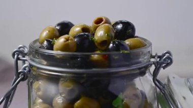 Cam bir kavanozda siyah ve yeşil zeytin. Lezzetli, marine edilmiş zeytin. Akdeniz yemekleri