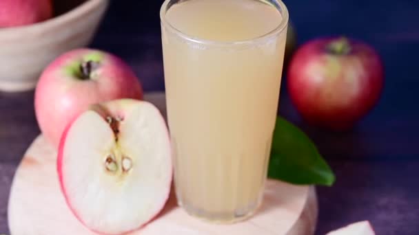新鮮な赤いリンゴとアップルジュースを飲みます 青鮮やかな背景 — ストック動画