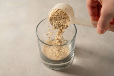 Bardakta, kepçeden protein tozu dök. Protein içeceği