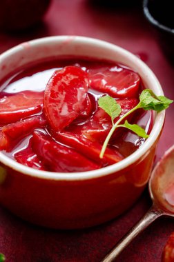 Kapalı kırmızı erikler konfeksiyon, reçel ya da meyve sosu bir kasede, üst manzara.