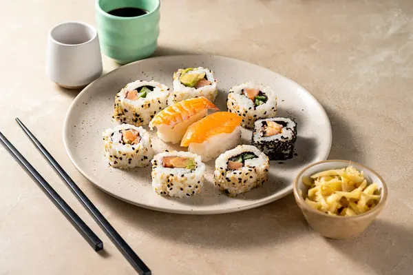 Suşi yuvarlak tabakta somon, karides ve avokado ile yakın çekim yapar.
