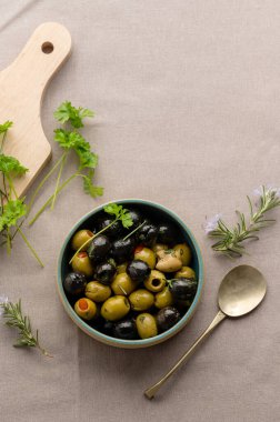 Bir kasede siyah ve yeşil zeytin. Lezzetli, marine edilmiş zeytin. Akdeniz yemekleri