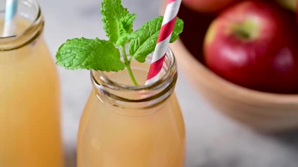 Äppeljuice Glasflaskor Med Färska Mynta Och Röda Äpplen — Stockvideo