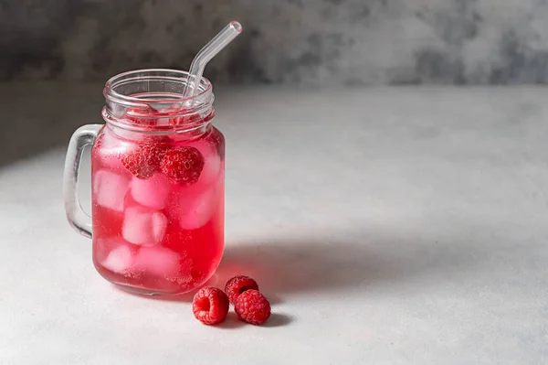 Raspberry refreshing lemonade in mason jar with glass straw, summer cold drink