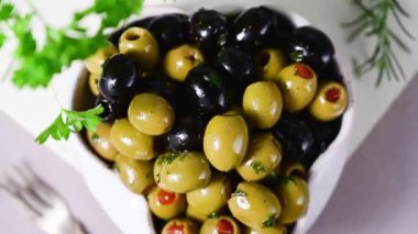 Bir kasede siyah ve yeşil zeytin. Lezzetli, marine edilmiş zeytin. Akdeniz yemekleri