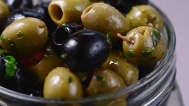 Cam bir kavanozda siyah ve yeşil zeytin. Lezzetli, marine edilmiş zeytin. Akdeniz yemekleri