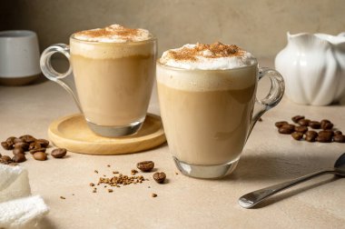 Two glass cups with coffee drink, latte with milk foam