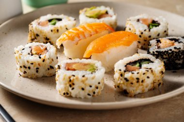 Suşi yuvarlak tabakta somon, karides ve avokado ile yakın çekim yapar.