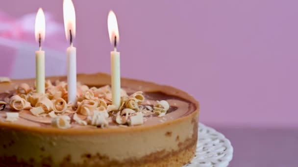 Τρία Αναμμένα Κεριά Στο Ροζ Φόντο Του Cheesecake Γενεθλίων Υψηλής — Αρχείο Βίντεο