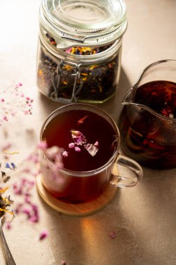 Kurumuş çiçekli bir bardak siyah yaprak çayı. Çay konsepti içmek. Yumuşak odak.