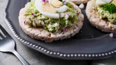 Avokado ton balığı salatası, pirinç keki, kırmızı soğan ve haşlanmış yumurta.