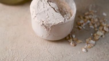 Protein tozu kepçeyle, protein içeceği de arka planda.