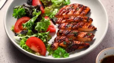 Izgara tavuk göğsü ve tabakta taze salata.