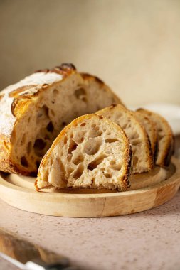 Ekşi hamurlu ev yapımı ekmek kesim tahtasında dilimlenmiş, karamsar yemek fotoğrafı.