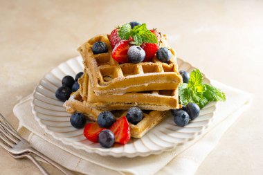 Çilekli, yabanmersinli ve pudra şekerli Belçika ev yapımı waffle 'lar.