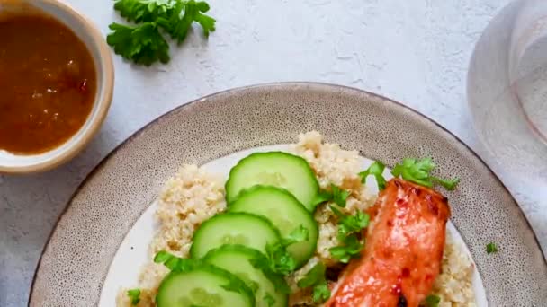 健康食品 带有烤红鱼 鲑鱼和新鲜黄瓜的藜麦 — 图库视频影像